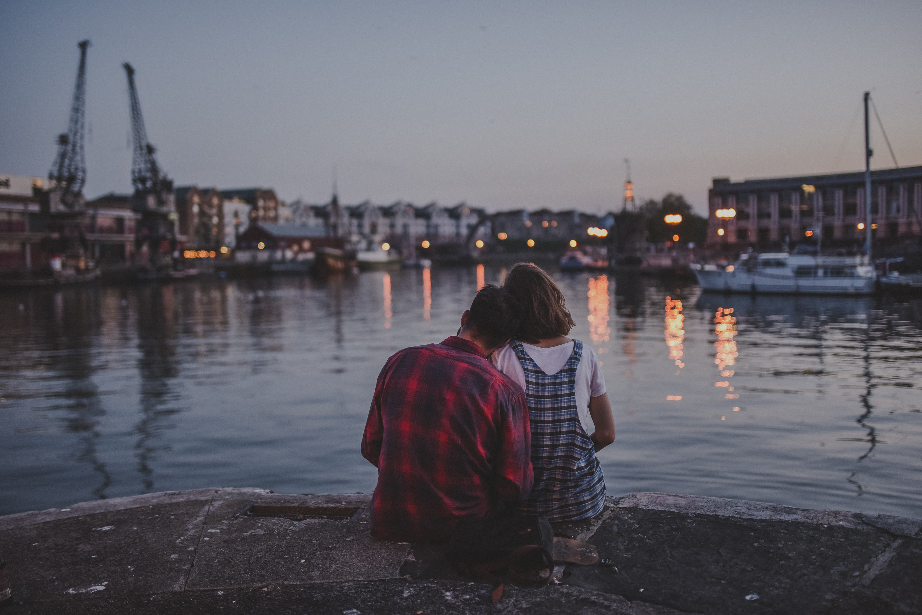 Thalia and Hal sitting together by the water at dusk